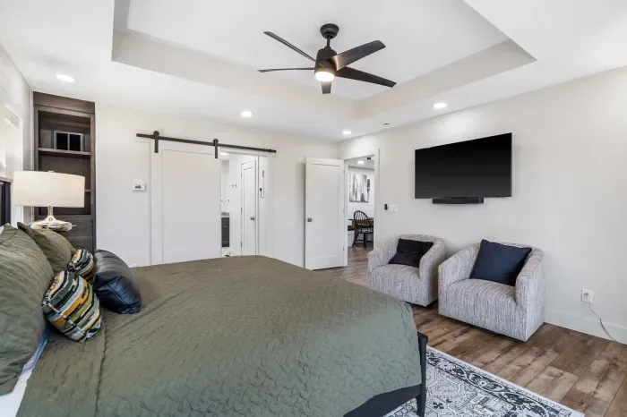 The primary king suite boasts a luxe private ensuite, deck access, & smart TV