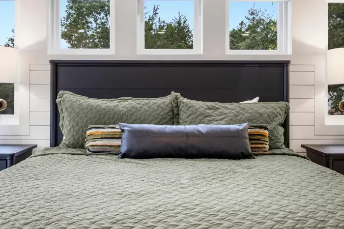 The primary king suite boasts a luxe private ensuite, deck access, & smart TV
