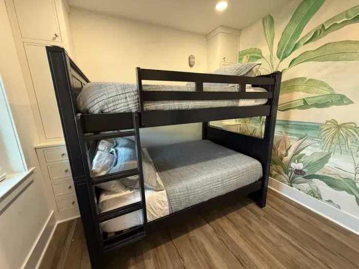 Bunk room with full-size bunk bed and twin trundle (not shown), coastal mural