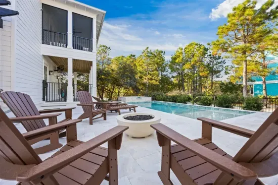 A private outdoor retreat where Adirondack chairs gather around a glowing fire bowl beside the pool and spa. Designed for slow mornings, sun-filled afternoons, and relaxed evenings under the coastal sky.