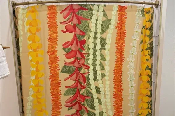 Family bunkroom bath featuring a colorful lei-inspired shower curtain
