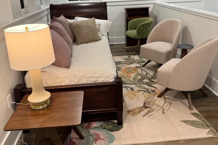 Loft sleeping area with twin daybed, trundle, seating, and secretary desk