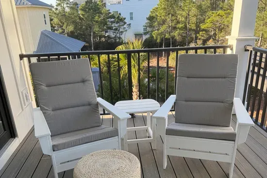 Gather on the upper back porch with room for the whole group — two separate seating areas of Adirondack chairs, ottomans, and a swing bed tucked in for an afternoon nap.