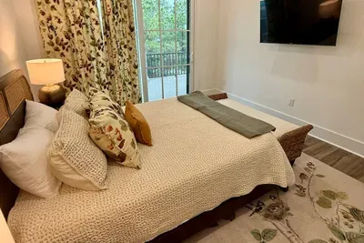 Tuck into bed here and step out to the shared porch overlooking the pool come morning — this butterfly-print guest room is calm, cozy, and all its own.