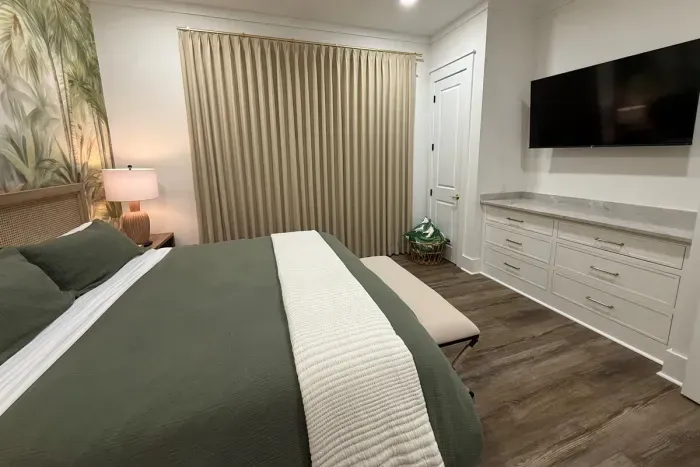 Downstairs master with blackout drapery, 55-inch TV, built-in dresser