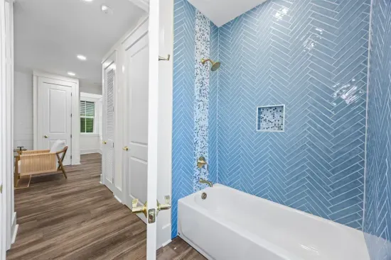 Step into the tiled tub to shower off the sand, just steps from the bunk room, with warm brass fixtures adding a nice touch.