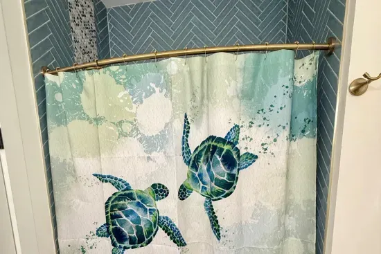 Spot the sea turtle on the shower curtain — a nod to island getaways in this guest house bath. The palm-and-toucan mural next door carries the same tropical spirit.