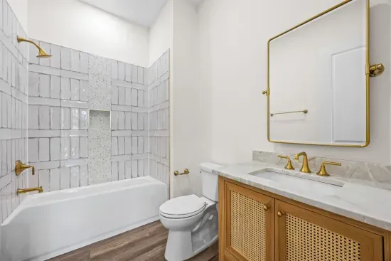 Step into this classic tub-shower combo to rinse off after beach day, vibrant brushed brass fixtures adding a little polish to bunk-room mornings (shower curtain not shown).