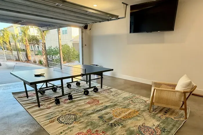 Game room - ping pong, 65-inch TV, dart board (not shown), wall-mounted Ms. Pac-Man (not shown), bistro table and chairs, sitting area