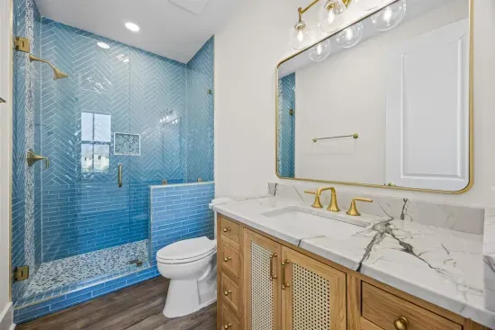 Get ready at the quartzite vanity, then step into the guest house's own walk-in shower — the perfect ensuite for the spacious, private primary bedroom.