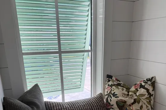 Tuck into this window seat just beyond the foyer in the stairwell landing — a quiet, light-filled spot for coffee, a book, or a few minutes to yourself, just steps from all the action.