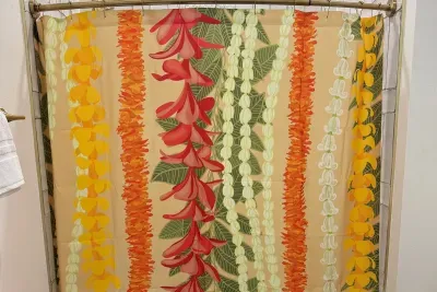 Rinse the day's sand away beneath a playful lei-print shower curtain and fully tiled tub surround — a colorful nod to the tropical green-and-orange palette right next door.