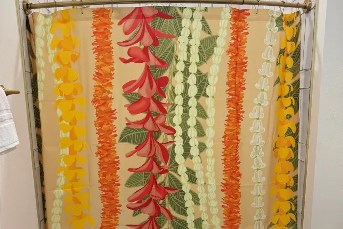 Family bunkroom bath featuring a colorful lei-inspired shower curtain