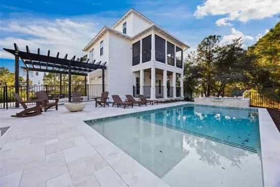 Wander the pool deck and settle into a lounger with both homes framing the view — porches stacked above you on every side.