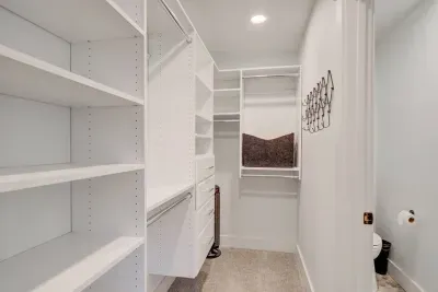 Walk in closet with hangers and a space fan in case you need a little extra air!