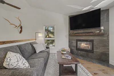Cozy lounge with fireplace, big-screen TV, and stylish rustic touches