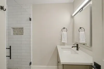 Modern bathroom with glass walk-in shower and bright vanity lighting