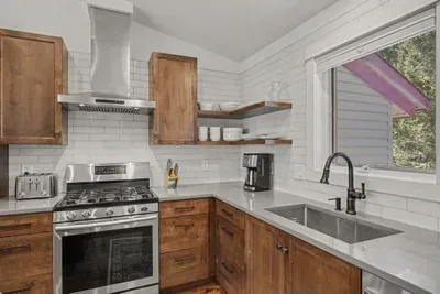 Bright modern kitchen with stainless appliances and warm wood finishes