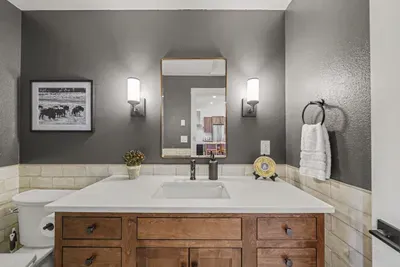 Modern bathroom with wood vanity, elegant lighting, and sleek finishes
