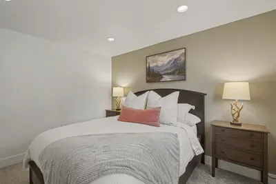 Cozy, well-styled bedroom with plush bedding and warm bedside lighting