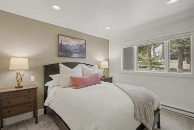 Bright, cozy bedroom with tree views and warm, welcoming touches