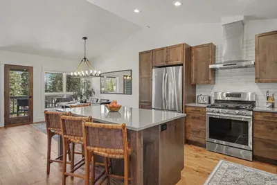 Bright mountain-view kitchen with island seating and stainless appliances