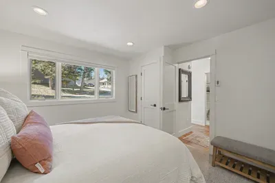 Bright, cozy bedroom with plush bedding and sunny window views