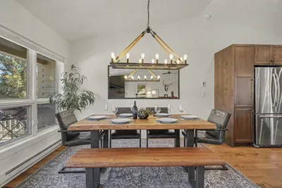 Bright rustic dining space with designer lighting and warm wood accents