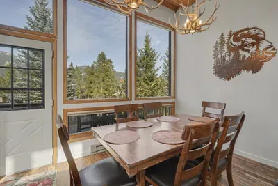 Sunlit dining space with mountain views and cozy rustic lodge charm