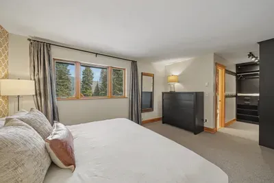 Bright, spacious bedroom with forest views and ample storage