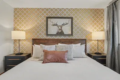 Cozy lodge-style bedroom with king bed and designer accent wall
