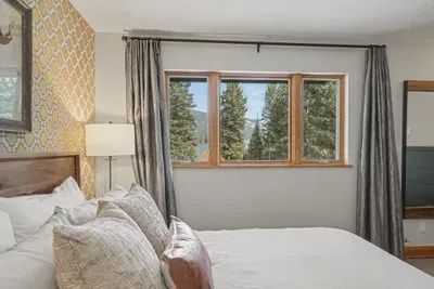 Cozy bedroom with forest views and warm mountain-lodge charm