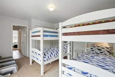 - Bunk room with two sturdy white bunk beds, sleeping up to four guests comfortably  - Playful ocean themed bedding brings a fun touch for younger visitors  - Neutral flooring and soft lighting create a cozy retreat for rest and play