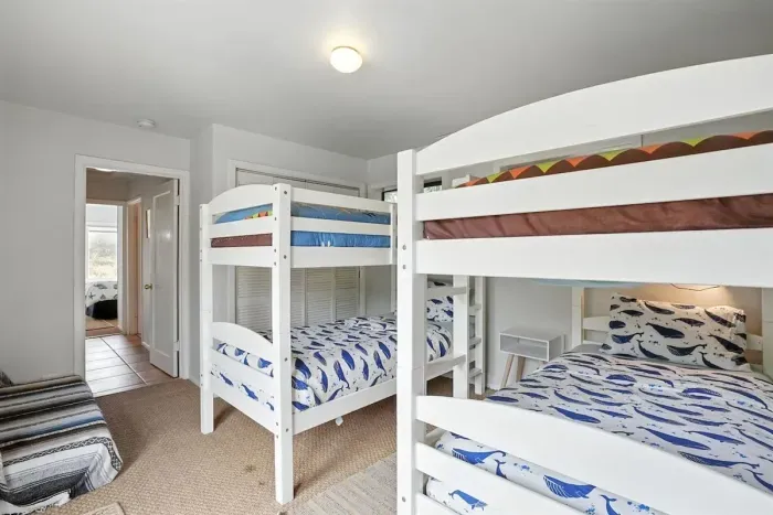 - Bunk room with two sturdy white bunk beds, sleeping up to four guests comfortably  - Playful ocean themed bedding brings a fun touch for younger visitors  - Neutral flooring and soft lighting create a cozy retreat for rest and play