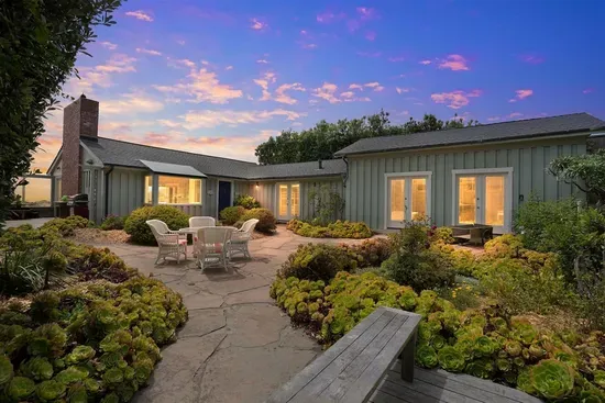 - Stunning courtyard with stone patio, beautiful greenery, and multiple seating areas  - Surrounded by the home’s charming architecture for a private outdoor retreat  - Warm evening lighting sets the perfect mood for dining or relaxing outdoors