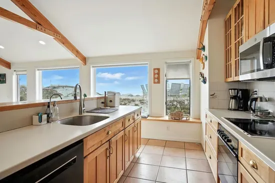 - Spacious kitchen with long counter space and deep sink, ideal for group meal prep  - Large windows provide natural light and sweeping views of surrounding dunes  - Fully equipped with modern appliances and wooden cabinetry for warmth