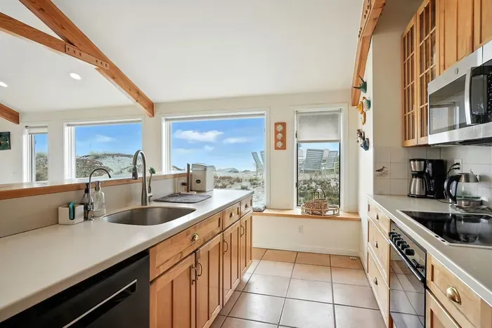 - Spacious kitchen with long counter space and deep sink, ideal for group meal prep  - Large windows provide natural light and sweeping views of surrounding dunes  - Fully equipped with modern appliances and wooden cabinetry for warmth
