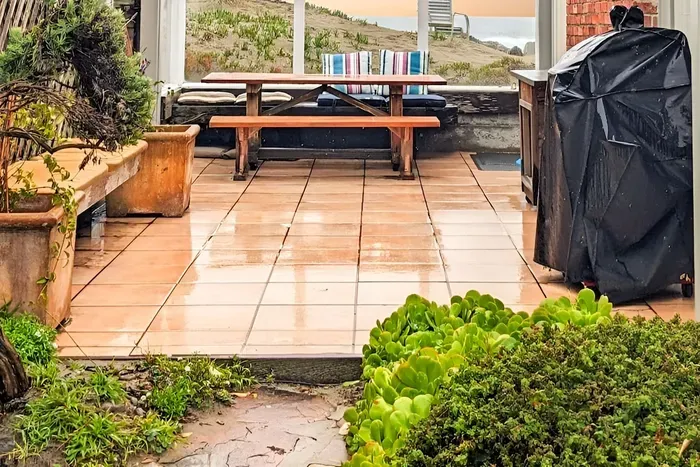 - Outdoor patio with picnic table, string lights, and views of the dunes  - Features BBQ grill for easy outdoor cooking and dining experiences  - Enclosed design offers a cozy gathering space in all seasons
