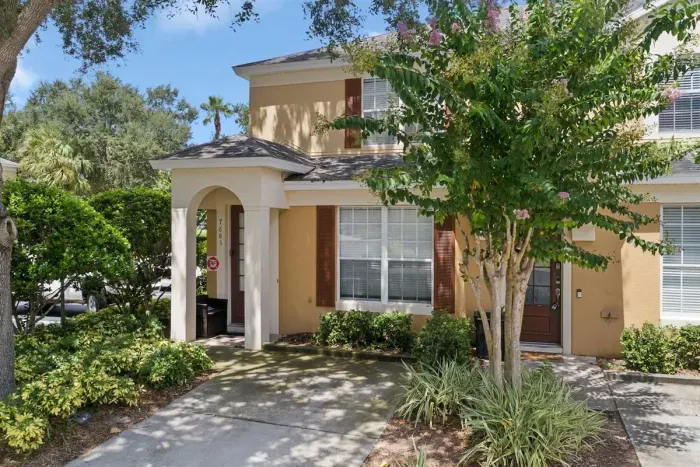 Front exterior of a two story villa with beautiful landscaping.