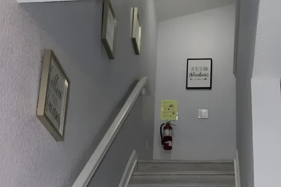 - Stairway with soft gray walls and motivational art for an inviting ascent  
- Wide steps and railing provide safety and ease for all guests  
- Leads to cozy upstairs bedrooms and additional living spaces