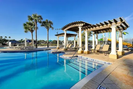 Resort pool with pergola shaded lounge seating.