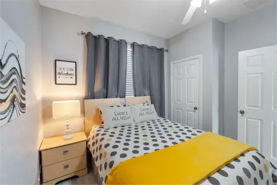 - Cozy guest bedroom with plush double bed and modern polka dot bedding  
- Warm yellow throw adds a cheerful pop of color to the soft gray palette  
- Perfect for couples or friends seeking a peaceful place to rest and recharge