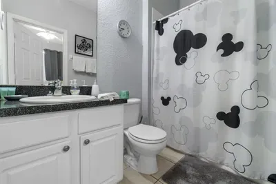 - Stylish bathroom with granite vanity and large mirror for a polished look  
- Mickey themed shower curtain adds a playful Disney touch to the space  
- Perfect mix of fun and function for guests of all ages to enjoy