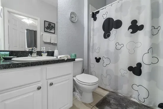 - Stylish bathroom with granite vanity and large mirror for a polished look  
- Mickey themed shower curtain adds a playful Disney touch to the space  
- Perfect mix of fun and function for guests of all ages to enjoy