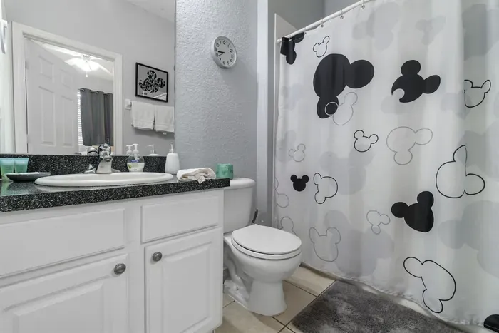 - Stylish bathroom with granite vanity and large mirror for a polished look  
- Mickey themed shower curtain adds a playful Disney touch to the space  
- Perfect mix of fun and function for guests of all ages to enjoy