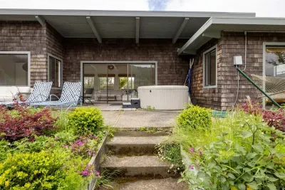 - Back patio with hot tub, lounge chairs, and beautiful garden landscaping  
- Steps lead directly from the house to this relaxing outdoor retreat  
- Perfect space to unwind and enjoy fresh air with a scenic waterfront view