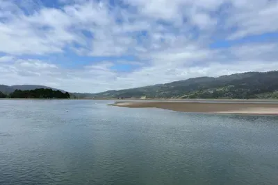 Stylish water views with rolling hills in the distance.