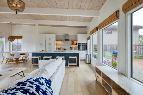 - Open living and kitchen layout with vaulted ceilings and wood flooring  
- Large windows overlook the courtyard, filling the space with sunlight  
- Kitchen island with bar seating is perfect for casual dining or drinks