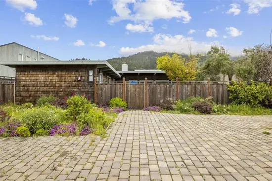 Driveway and front garden with colorful blooming plants.