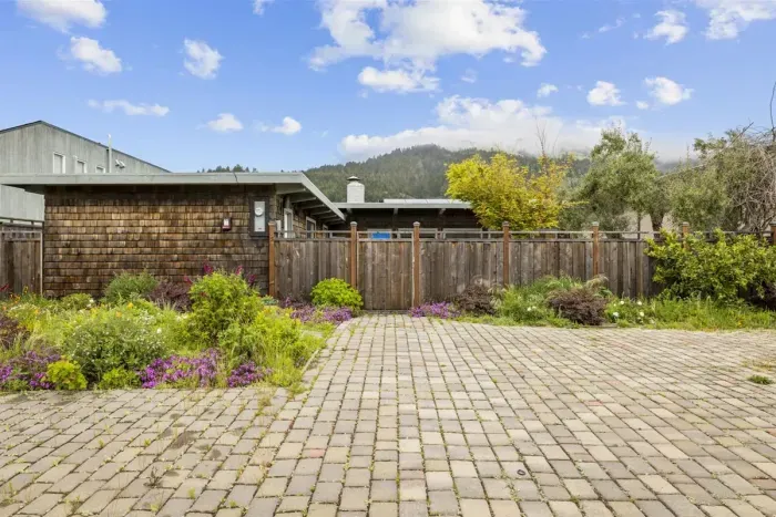 Driveway and front garden with colorful blooming plants.